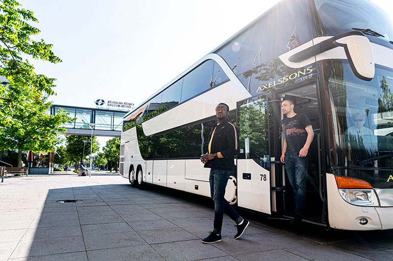 Studenter kliver av bussen framför campus Västerås