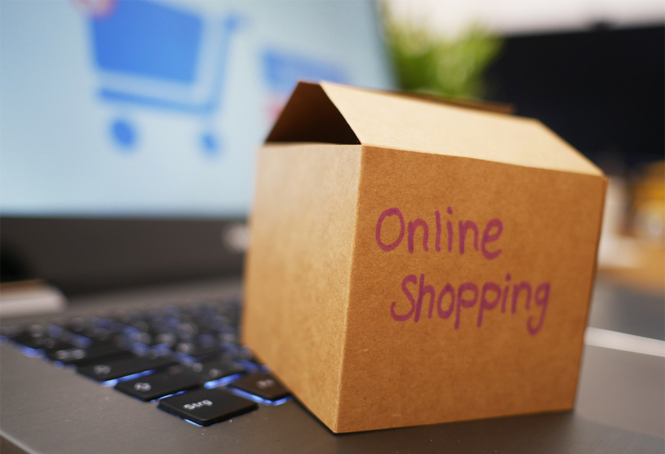 En miniatyrkartong står på ett tangentbord. Text på kartongen: Online shopping.