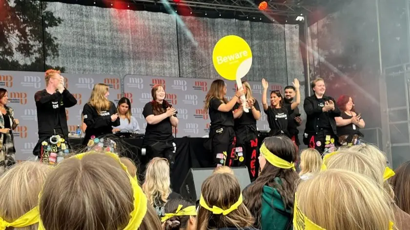 Flera personer på scenen som ser glada ut.