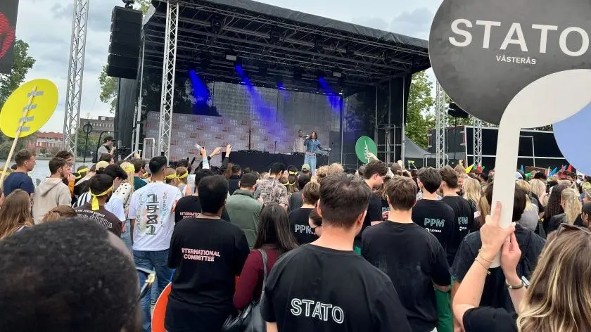 Kvinna står på scenen och sjunger.