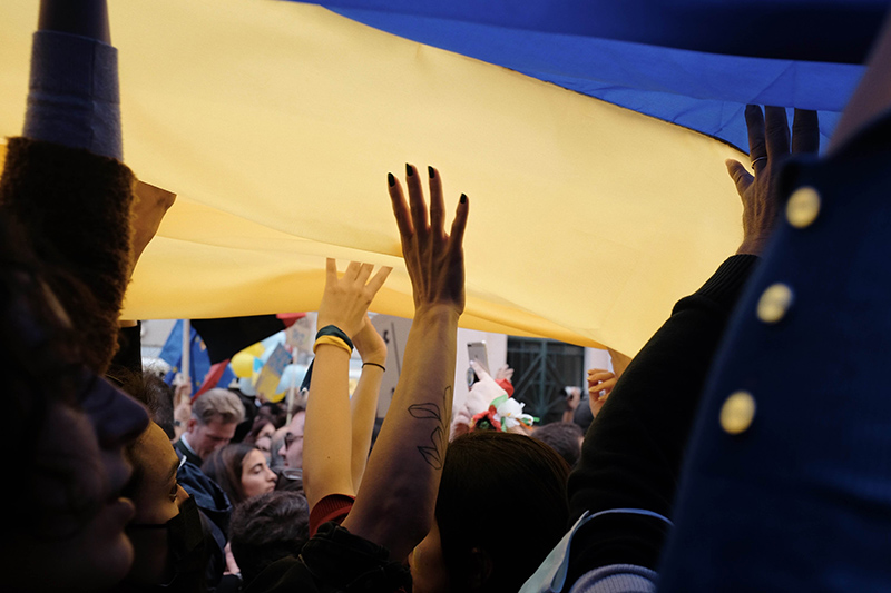 Folksamling och ukrainska flaggor. 